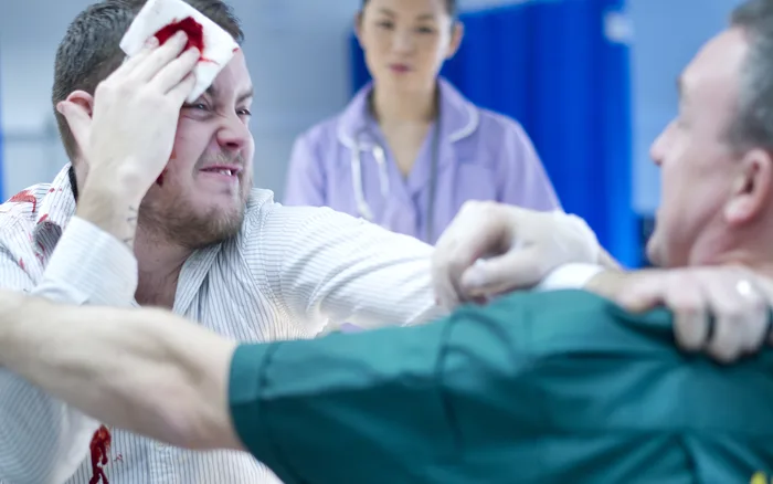 A paramedic restraining an aggressive patient